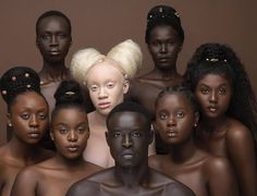 a group of naked black people with blonde hair and piercings on their heads, all looking at the camera