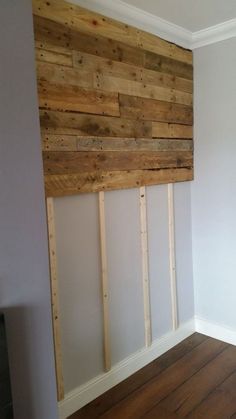 an empty room with wood planks on the wall and hard wood flooring in it