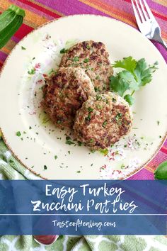 two meat patties on a white plate with parsley sprinkled around them