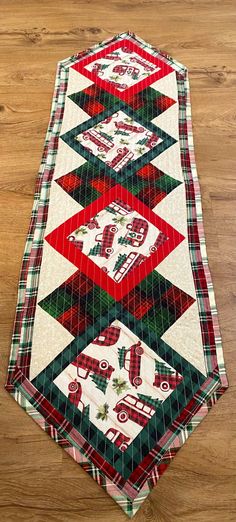 a quilted table runner on top of a wooden floor