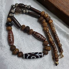 The amulet has seven eyes and features intricate carvings that speak to its cultural significance. The amulet is believed to have protective powers and is a unique addition to any collection. The agate material and Yak bone beads used in the amulet make it a one-of-a-kind piece. Spiritual Brown Carved Beads, Amulet Necklace With Oval Beads, Spiritual Agate Jewelry With Wooden Beads, Adjustable Carved Spiritual Necklace, Spiritual Carved Beaded Necklace As Gift, Spiritual Carved Beads For Healing, Spiritual Carved Beaded Necklace For Gift, Carved Beaded Necklaces For Spiritual Gifts, Amulet Style Wooden Beaded Necklace