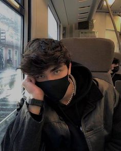 a man wearing a face mask on a train