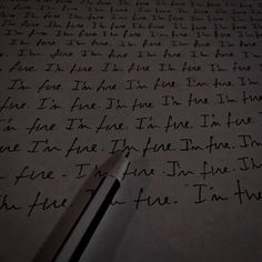 a piece of paper with writing on it and a pen laying next to it in the dark