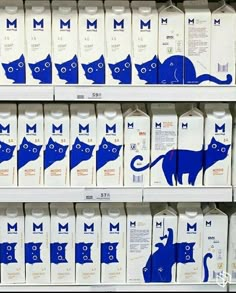 milk cartons with blue cats on them in a grocery store display case, one for milk and the other for milk