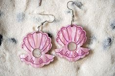 Catch the wave with these bright pink Clam and Pearl acrylic earrings! Perfect for those who can't get enough of the beach or who love to stand out with unique, eye-catching jewelry these sparkly earrings add a splash of ocean fun to any outfit. Whether you're beach-bound or just daydreaming of the sea, these funky earrings are sure to turn heads. Dive into your summer style with these eye-catching accessories! 🌊🐚 -Earrings measure about 2.5in tall with hook included, and about 1.4in wide *Jewelry hardware crafted from tarnish resistant and sturdy hypoallergenic surgical stainless steel. *Keep out of direct sun exposure for prolonged periods. *Refrain from exposing to water, fragrances, or harsh chemicals. *For cleaning, use a soft cloth with gentle strokes, avoiding painted sections. Pink Pierced Earrings As Gift, Pink Dangle Earrings For Beach, Pink Beach Jewelry With Matching Earrings, Pink Jewelry With Matching Earrings For Beach, Unique Nickel-free Pink Earrings, Unique Nickel Free Pink Earrings, Pink Dangle Plug Earrings, Pink Dangle Plug Earrings For Pierced Ears, Unique Pink Pierced Earrings