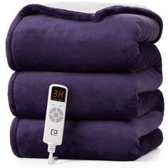 a stack of purple blankets with an electronic thermometer on each one and two piles of them