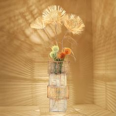 a vase filled with flowers sitting on top of a wooden table next to a wall