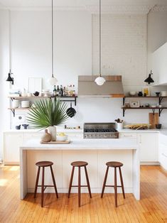 a kitchen with two stools and an island