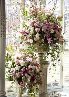 two vases filled with flowers sitting next to each other on a window sill