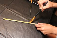 a person is using a large pair of scissors to cut out the sides of a piece of wood