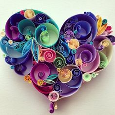 a heart shaped sculpture made out of paper quirky colors and swirls on a white background