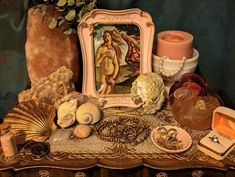 there are many items on this table including shells, candles, and other decorative objects