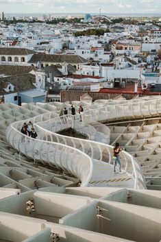 people are standing on the roof of a building with many white structures in front of them