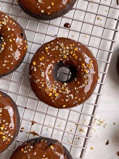 chocolate donuts with sprinkles on a cooling rack