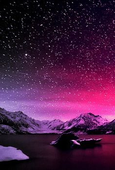 the night sky is filled with stars and purple hues as well as snow covered mountains