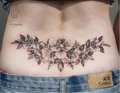 a woman's stomach with flowers and leaves on it