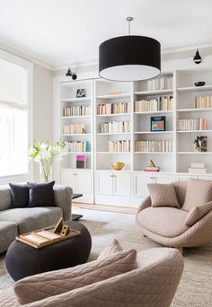 a living room filled with furniture and bookshelves