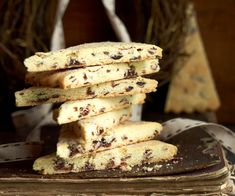 a stack of chocolate chip cookies sitting on top of a wooden table next to a white bag