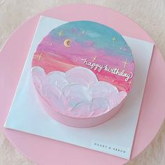 a pink and blue birthday cake sitting on top of a white plate with the words happy birthday written on it