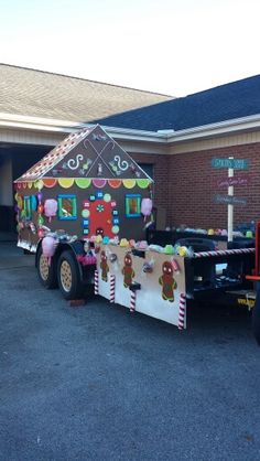 a large trailer decorated with gingerbreads is parked in front of a brick building