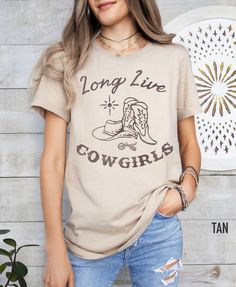 Saddle up and show off your cowgirl spirit with our Western-inspired T-shirt. Featuring a captivating western graphic, this tee pays homage to the fearless spirit of cowgirls everywhere. With the rallying cry 'Long Live Cowgirls,' it celebrates the strength, independence, and timeless allure of the women who ride the range. Whether you're a seasoned wrangler or just love the frontier vibe, this tee is a tribute to the enduring legacy of the wild west and the fierce individuals who call it home. Relaxed Fit Tops For Country Concerts, Graphic Tee With Text Print For Country Concerts, Short Sleeve Tops With Letter Print For Country Concerts, Western Tee Shirts, Aesthetic Cow, Western Tshirt, Shirts Trendy, Western Tee, Western Aesthetic