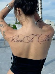 a woman with tattoos on her back and the words born to die written in cursive font