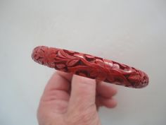 Here we have a Vintage Brick Red Floral Carved Cinnabar Bangle Bracelet, Summertime Floral Carved Bangle, Red Floral Bracelet, Nice Scarlet Floral Bangle. This is a nice Summertime Bangle Bracelet to add to one's collection should you wear bangles and it is in good condition. There is no marking on this Bangle but is in good condition and it is 3 1/4 inches wide from the outside to the outside and it is 2 1/2 inches wide inside and will look great should one have a red bathing suit... Any questi Red Ceremonial Bangle With Intricate Design, Traditional Carved Round Bangle, Traditional Carved Bangle Gift, Green Carved Round Bangle, Vintage Handmade Red Bangle, Red Bathing Suits, Red Bangles, Floral Bracelet, Bangles Style