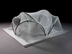 an artistic sculpture made out of mesh on a white surface with black background and shadow