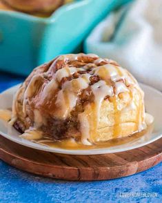 a bundt cake on a plate with icing and cinnamon rolls in the background