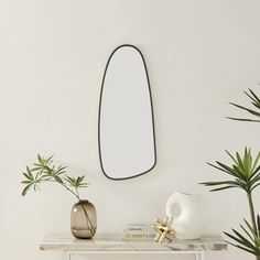 a white table topped with plants and a mirror