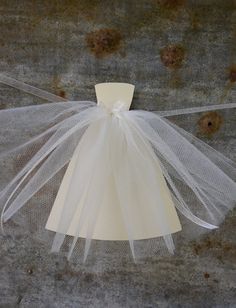 a white tulle dress hanging on a wall