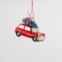 a red car ornament with a christmas tree on the roof hanging from it