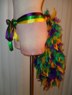 a white mannequin with multi colored feathers on it