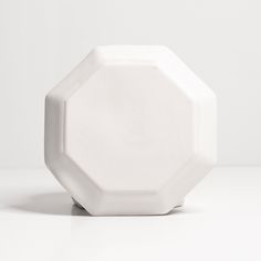 a white vase sitting on top of a table