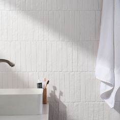 a bathroom sink with toothbrushes and soap in it next to a white towel