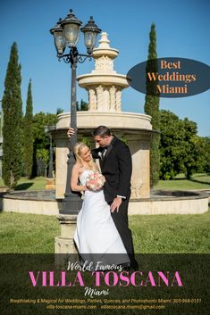 a bride and groom pose for a photo in front of a fountain