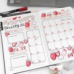 an open planner with strawberries on it next to a coffee cup and laptop computer