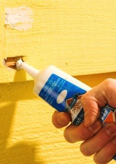 a person holding a tube of toothpaste in their left hand and the other hand is pointing at it