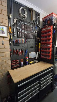 a workbench with many tools hanging on the wall