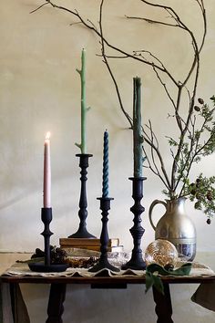 a table topped with candles next to a vase filled with flowers