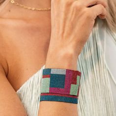 a woman is wearing a colorful bracelet on her wrist