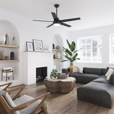 a living room filled with furniture and a fire place under a ceiling fan on top of a hard wood floor