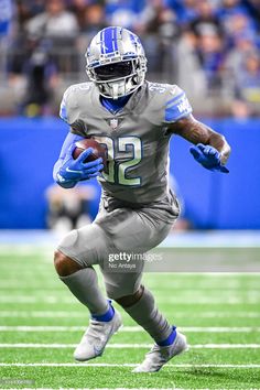 a football player running with the ball in his hands during a game against the giants