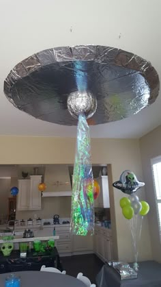 a ceiling light that is hanging from the ceiling in a kitchen with balloons and streamers