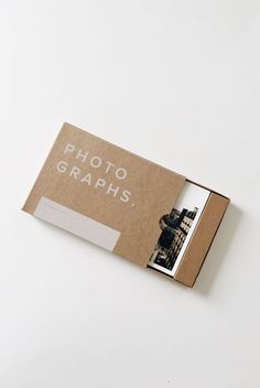 an open photo book sitting on top of a white table