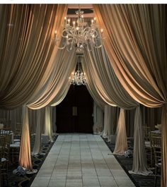 the entrance to a wedding ceremony with chandelier and drapes draped over it