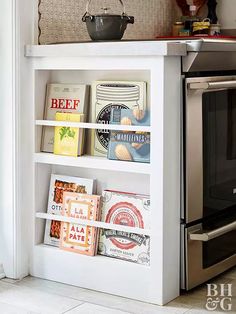 a white book shelf with books on top of it and an oven in the background