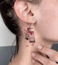 a woman with a tattoo on her neck and behind her ear is a bird in a cage