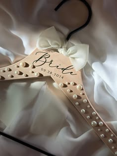 a bridal hanger with pearls and a bow on it