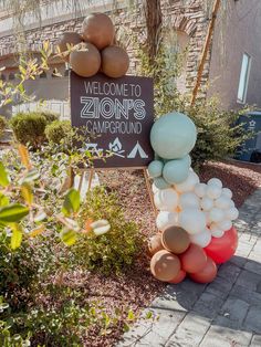 a welcome sign with balloons in front of it